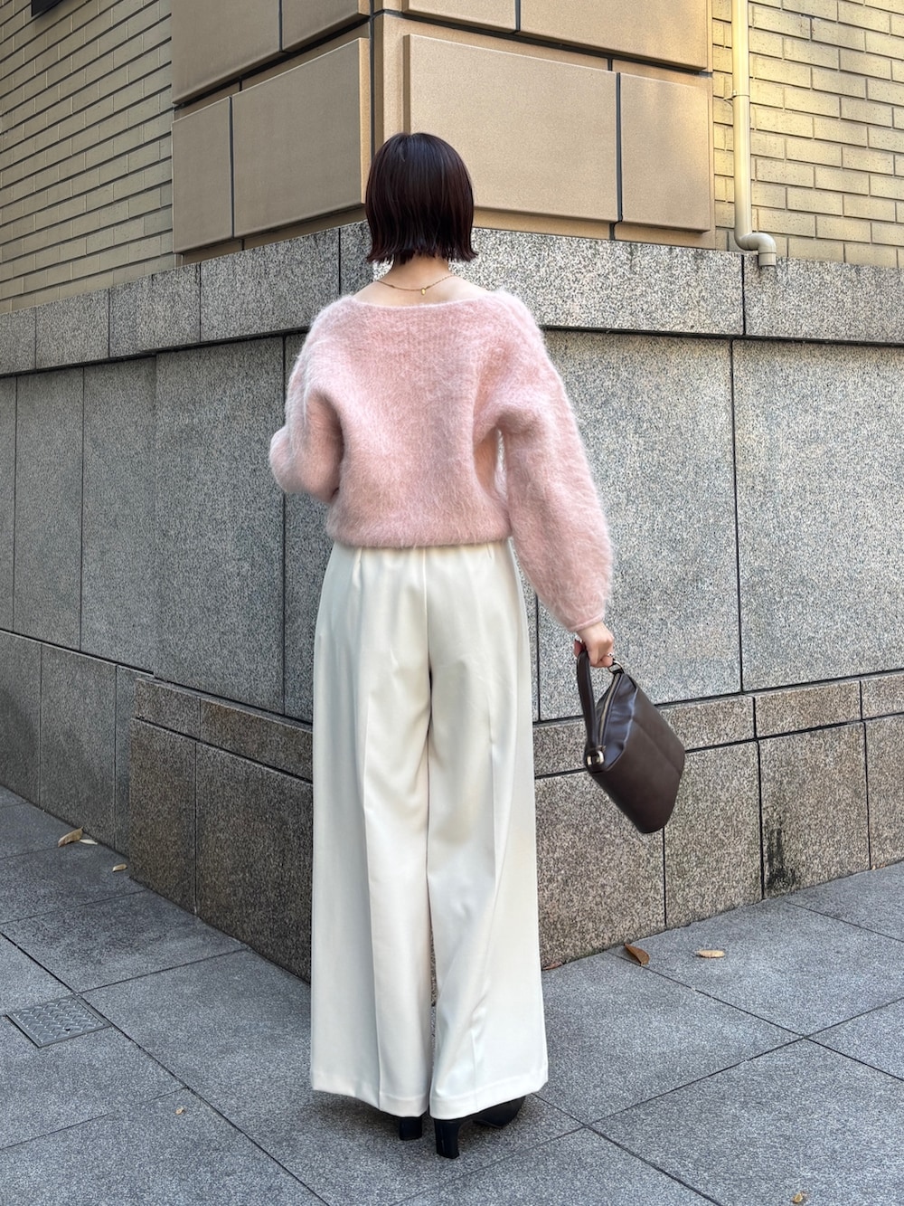 ピンク系のニット/セーター、ブラウン系のハンドバッグ、ホワイト系のその他パンツを着用したレディースの秋コーディネートの3枚目の写真
