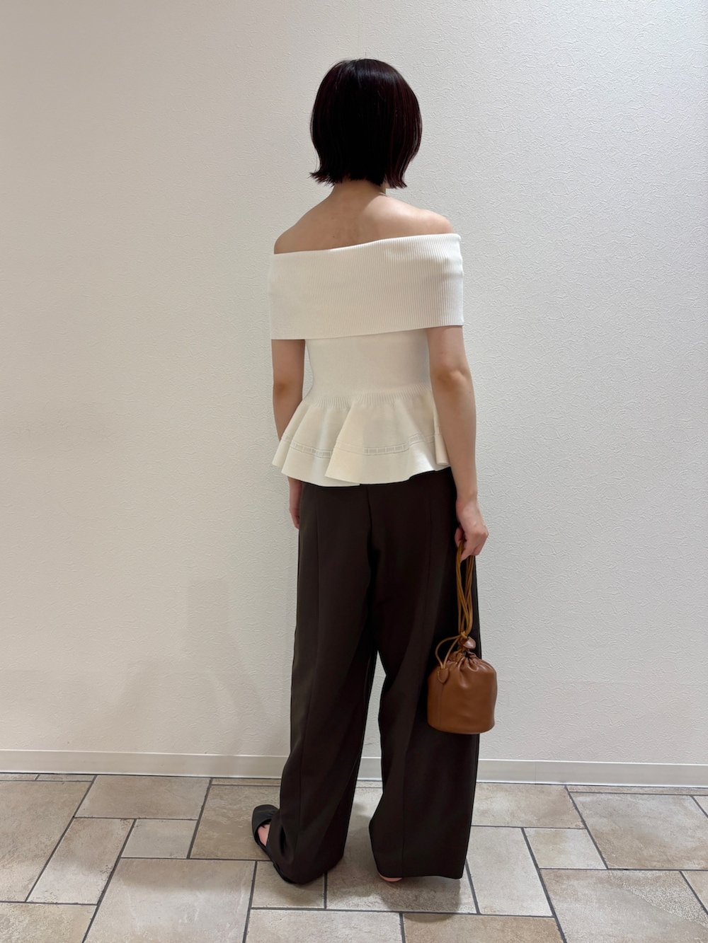 ブラウン系のその他パンツ、ホワイト系のニット/セーター、イエロー系のハンドバッグを着用したレディースの夏コーディネートの3枚目の写真