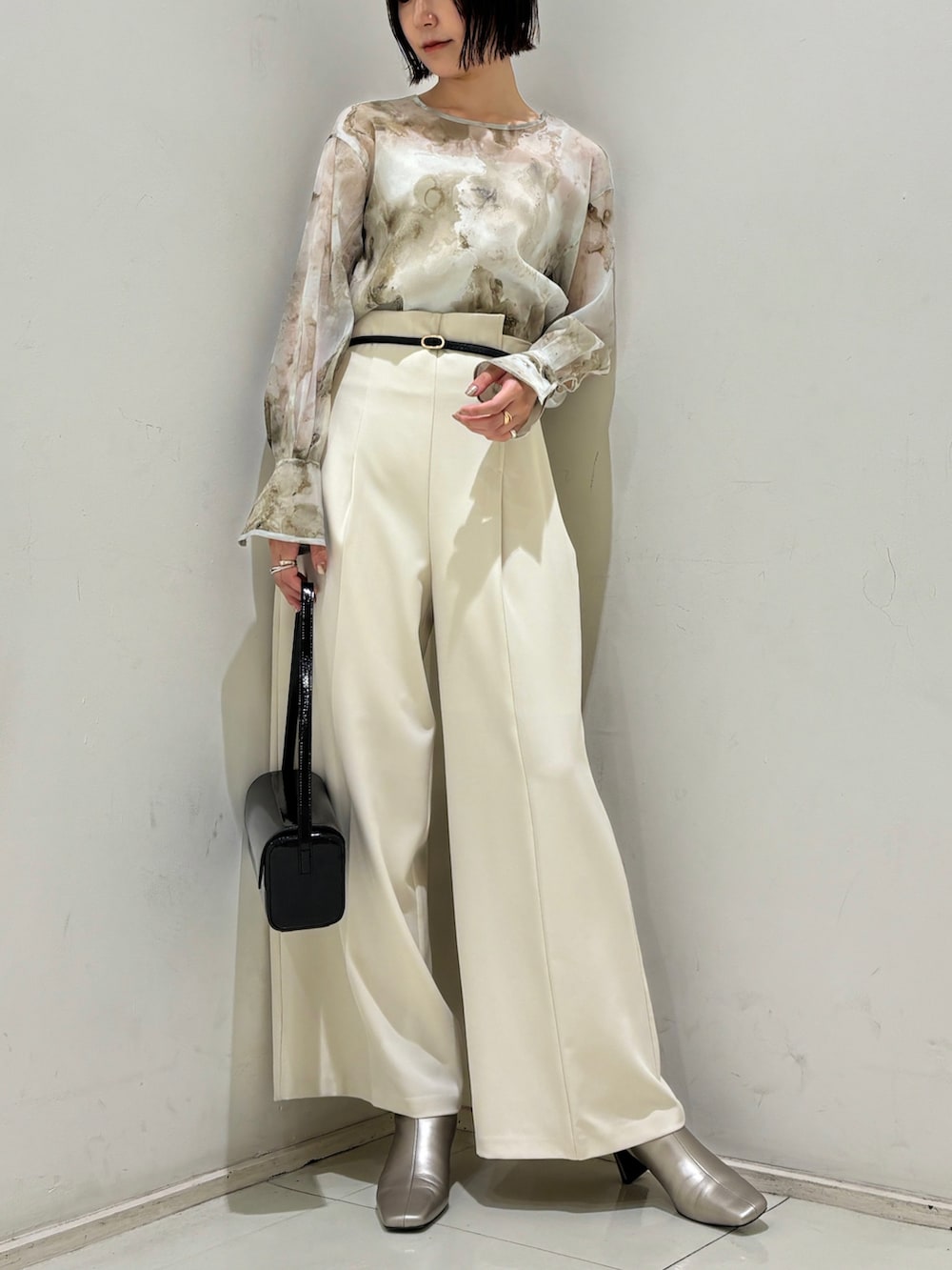 ホワイト系のその他パンツ、ブラック系のショルダーバッグ、シルバー系のブーツを着用したレディースの秋コーディネートの2枚目の写真