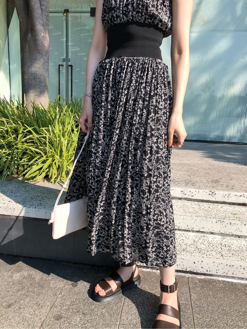 ホワイト系のショルダーバッグ、ブラック系のワンピース、ブラウン系のサンダルを着用したレディースの夏コーディネートの4枚目の写真