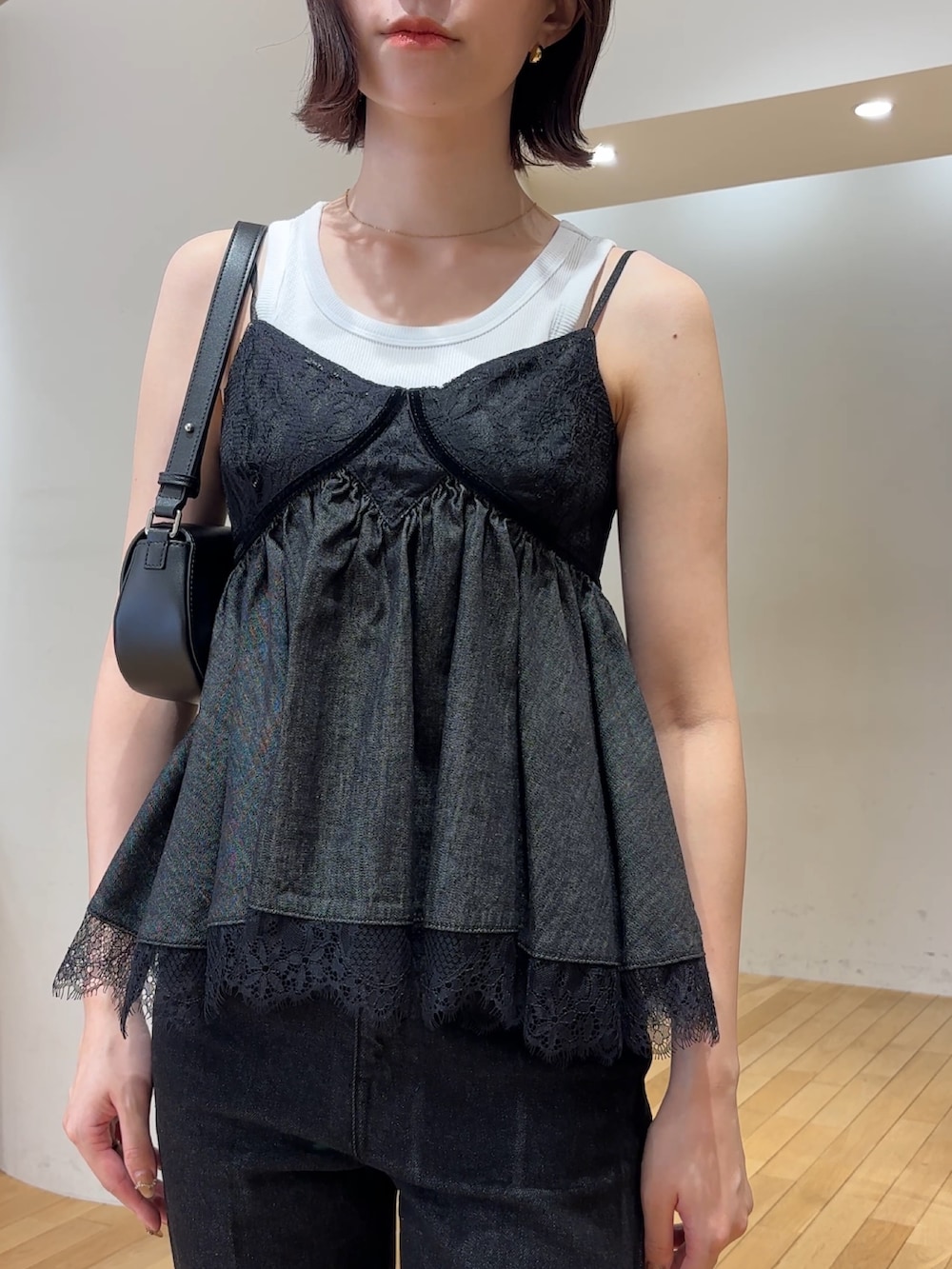 ブラック系のデニムパンツ、シルバー系のパンプス、ホワイト系のタンクトップを着用したレディースの夏コーディネートの5枚目の写真
