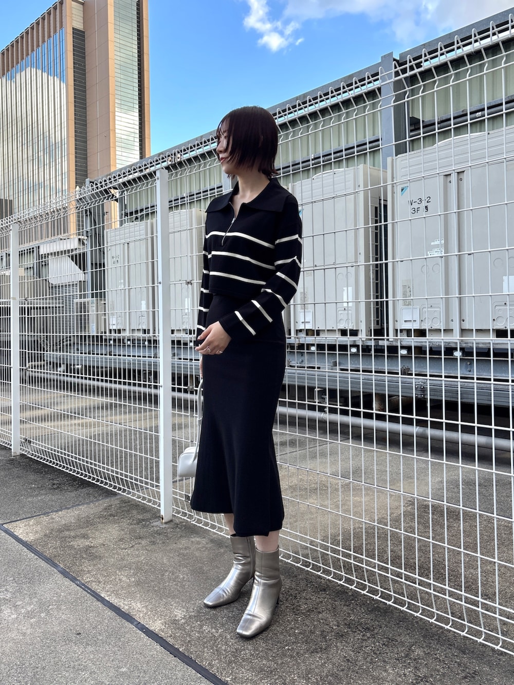 ブラック系のニット/セーター、ブラック系のスカート、グレー系のムートンコートを着用したレディースの冬コーディネートの2枚目の写真