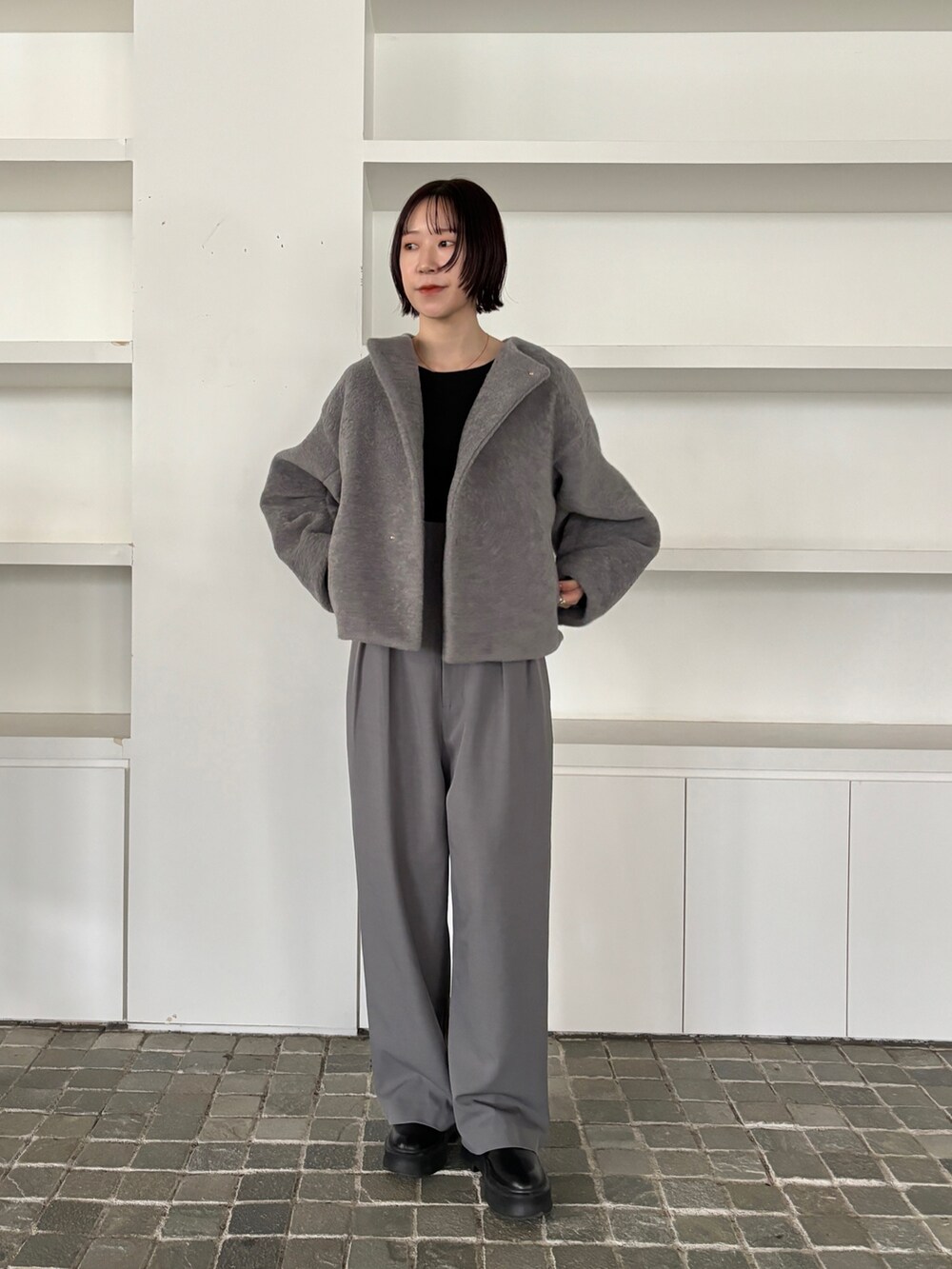 グレー系のブルゾン、グレー系のその他パンツ、ブラック系のブーツを着用したレディースの秋コーディネートの2枚目の写真