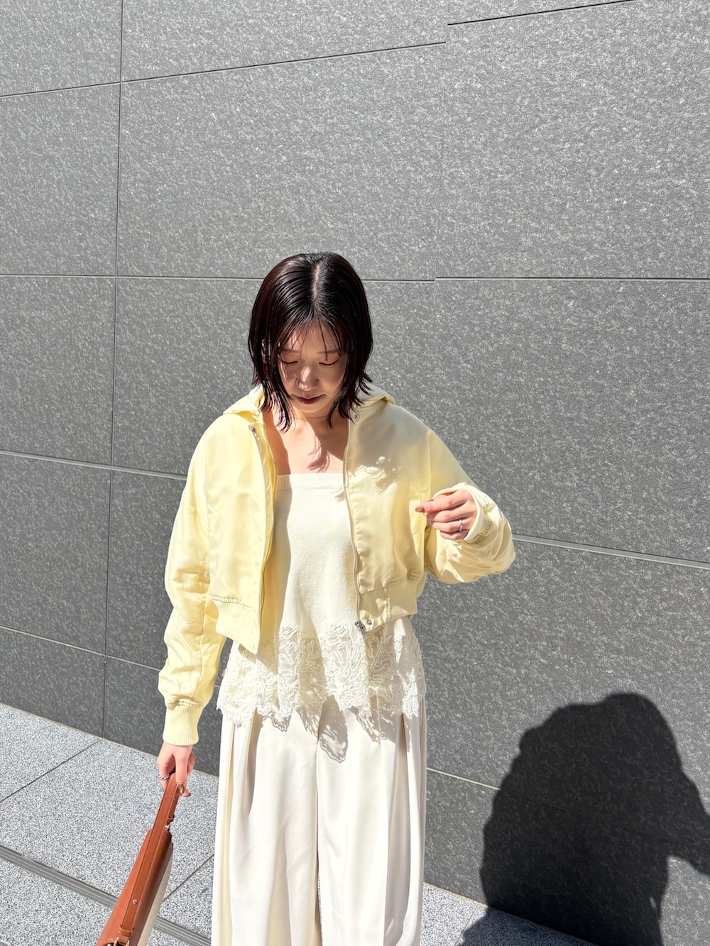 ホワイト系のその他パンツ、ブラウン系のハンドバッグ、イエロー系のブルゾンを着用したレディースの春コーディネートの4枚目の写真