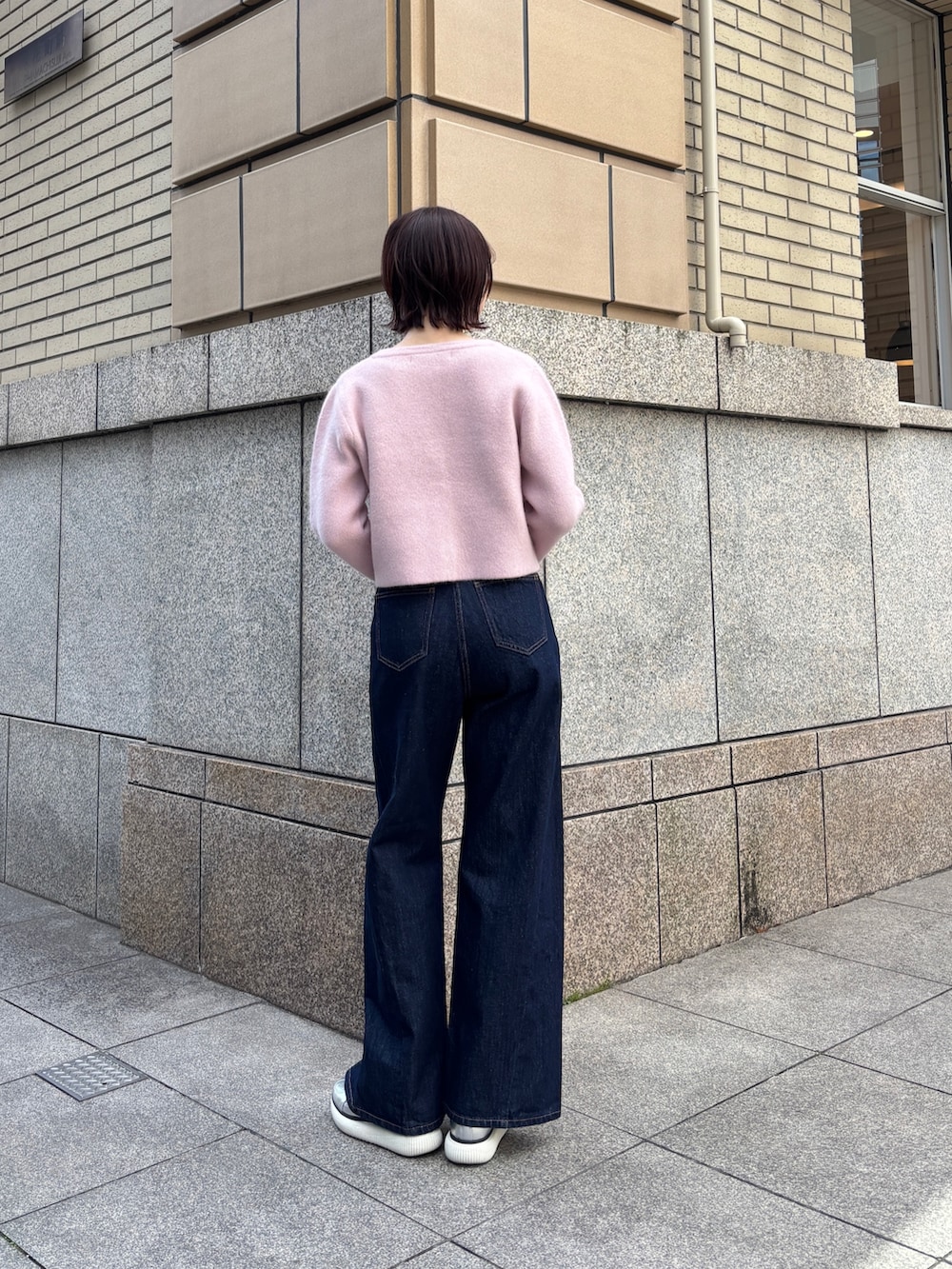 ブルー系のデニムパンツ、ピンク系のテーラードジャケット、イエロー系のハンドバッグを着用したレディースの冬コーディネートの3枚目の写真