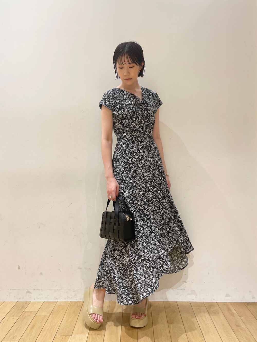 ブラック系のワンピース、ブラック系のショルダーバッグ、ベージュ系のサンダルを着用したレディースの夏コーディネートの2枚目の写真