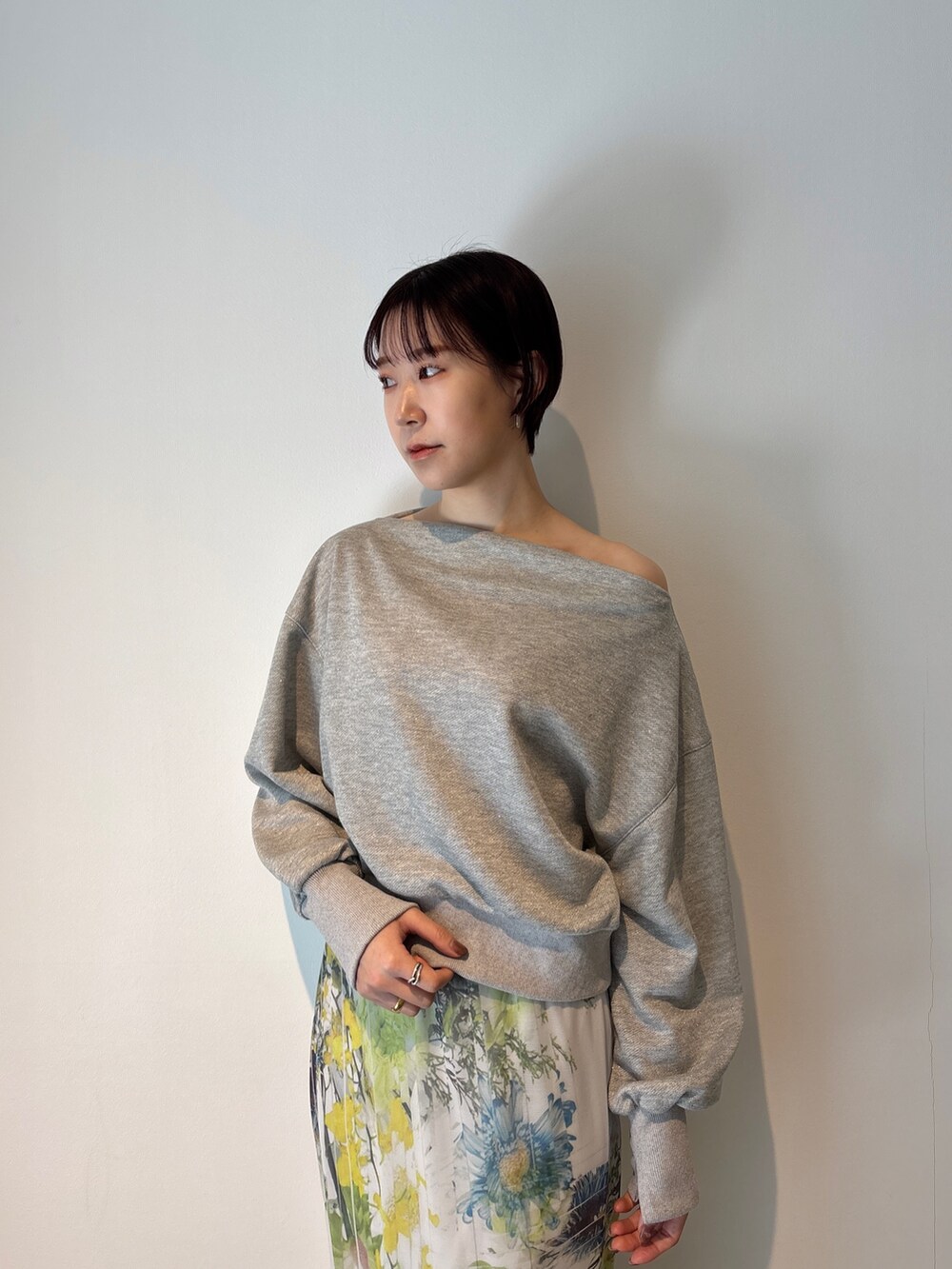 グレー系のスカート、グレー系のスウェット、ホワイト系のサンダルを着用したレディースの冬コーディネートの6枚目の写真