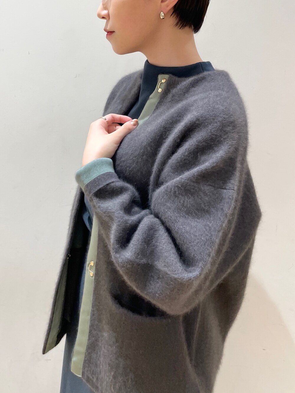 グレー系のカーディガン/ボレロ、グリーン系のニット/セーター、グリーン系のスカートを着用したレディースの冬コーディネートの8枚目の写真