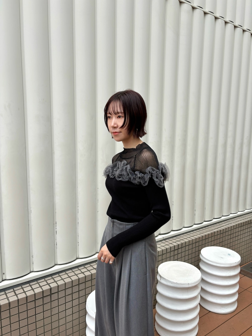グレー系のその他パンツ、ブラック系のニット/セーター、ブラック系のブーツを着用したレディースの秋コーディネートの5枚目の写真