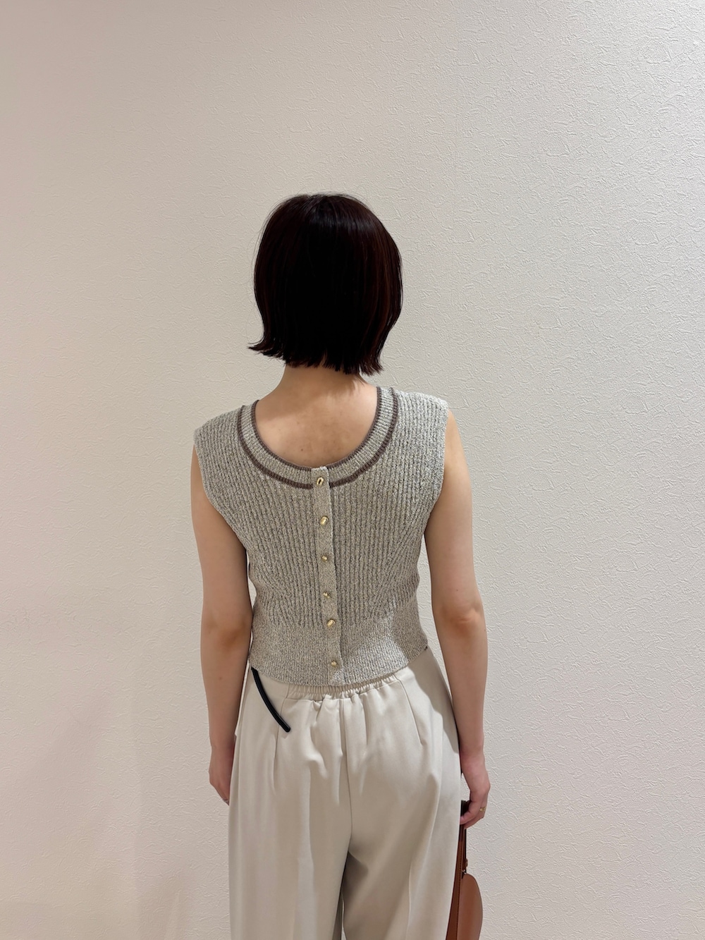 ホワイト系のその他パンツ、ホワイト系のサンダル、ブラウン系のハンドバッグを着用したレディースの夏コーディネートの5枚目の写真