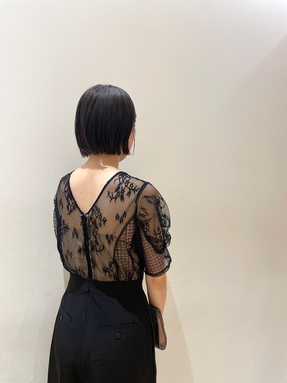 シルバー系のハンドバッグ、シルバー系のパンプス、ブラック系のパンツドレスを着用したレディースの夏コーディネートの8枚目の写真