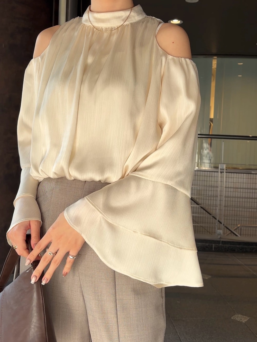 シルバー系のパンプス、ブラウン系のハンドバッグ、グレー系のその他パンツを着用したレディースの冬コーディネートの5枚目の写真