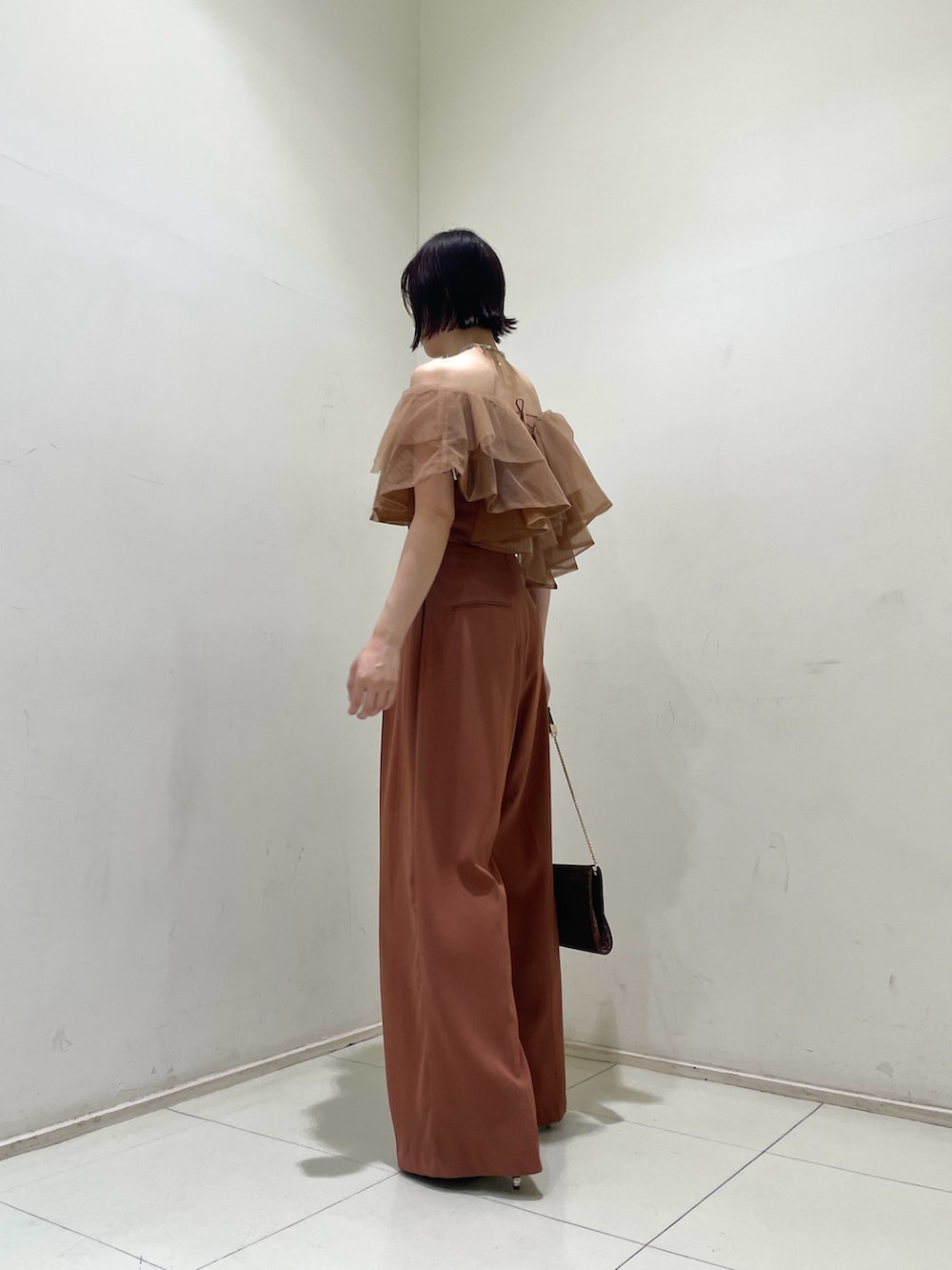 オレンジ系のパンツドレス、その他のクラッチバッグ、その他のパンプスを着用したレディースの夏コーディネートの3枚目の写真