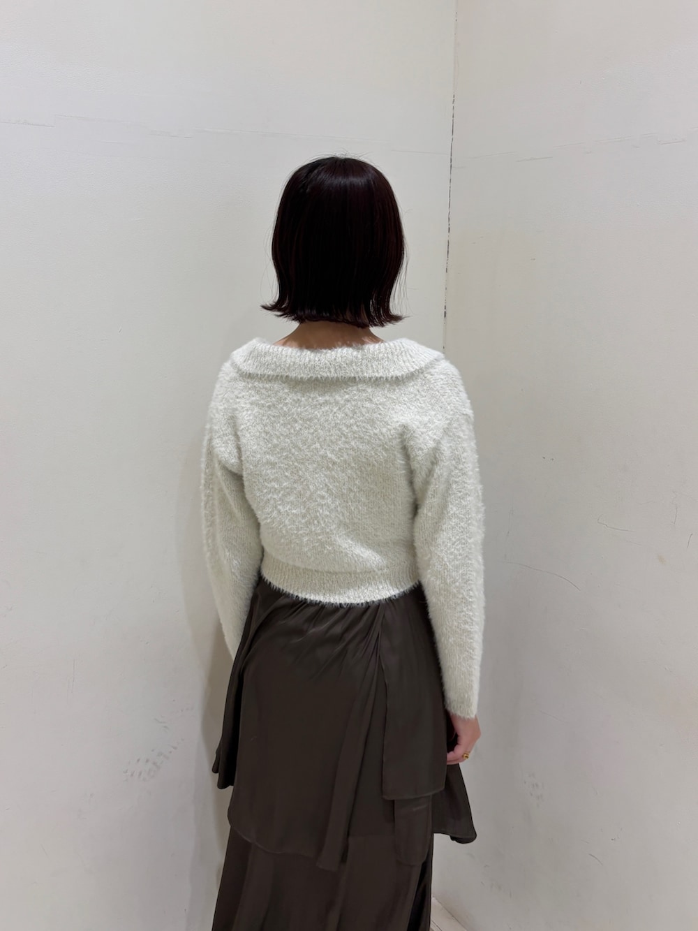 ブラウン系のスカート、ホワイト系のアンサンブルを着用したレディースの冬コーディネートの5枚目の写真