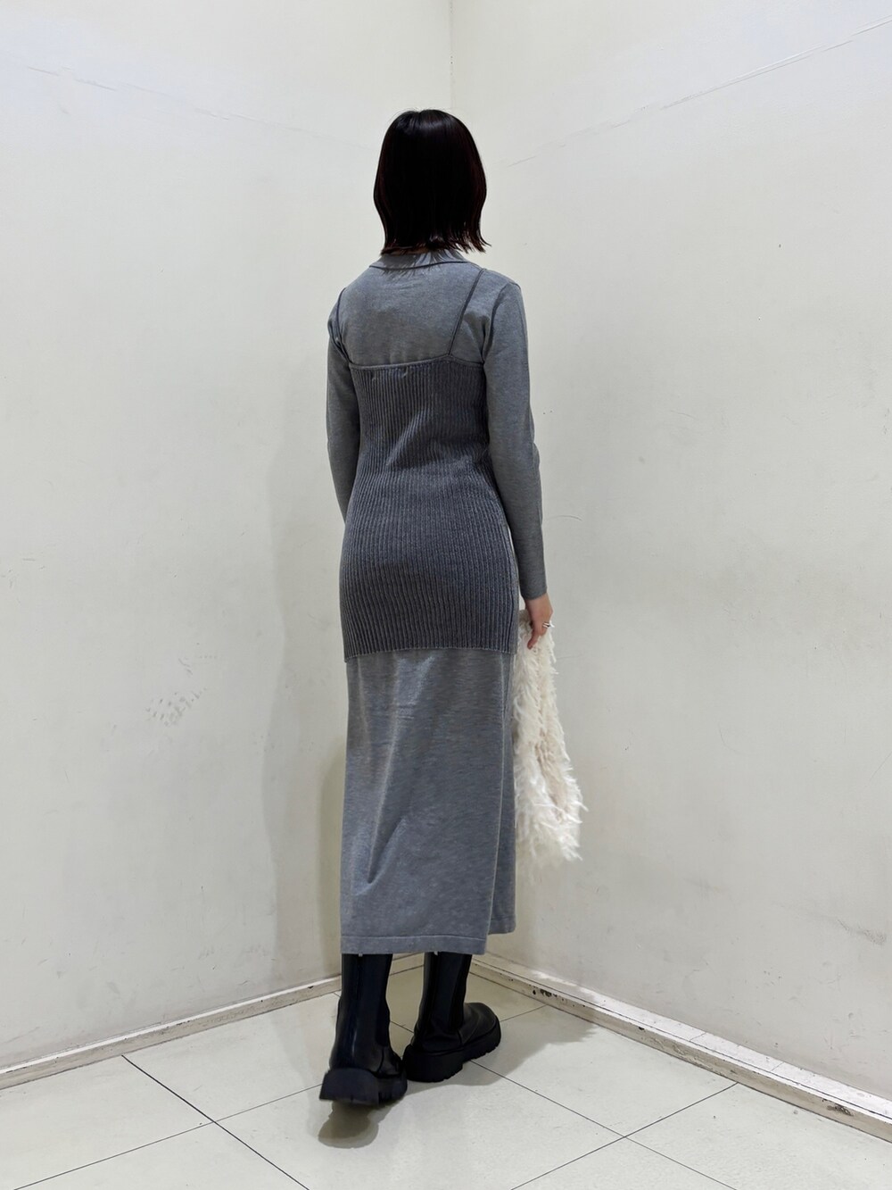 グレー系のワンピース、ホワイト系のハンドバッグを着用したレディースの冬コーディネートの4枚目の写真