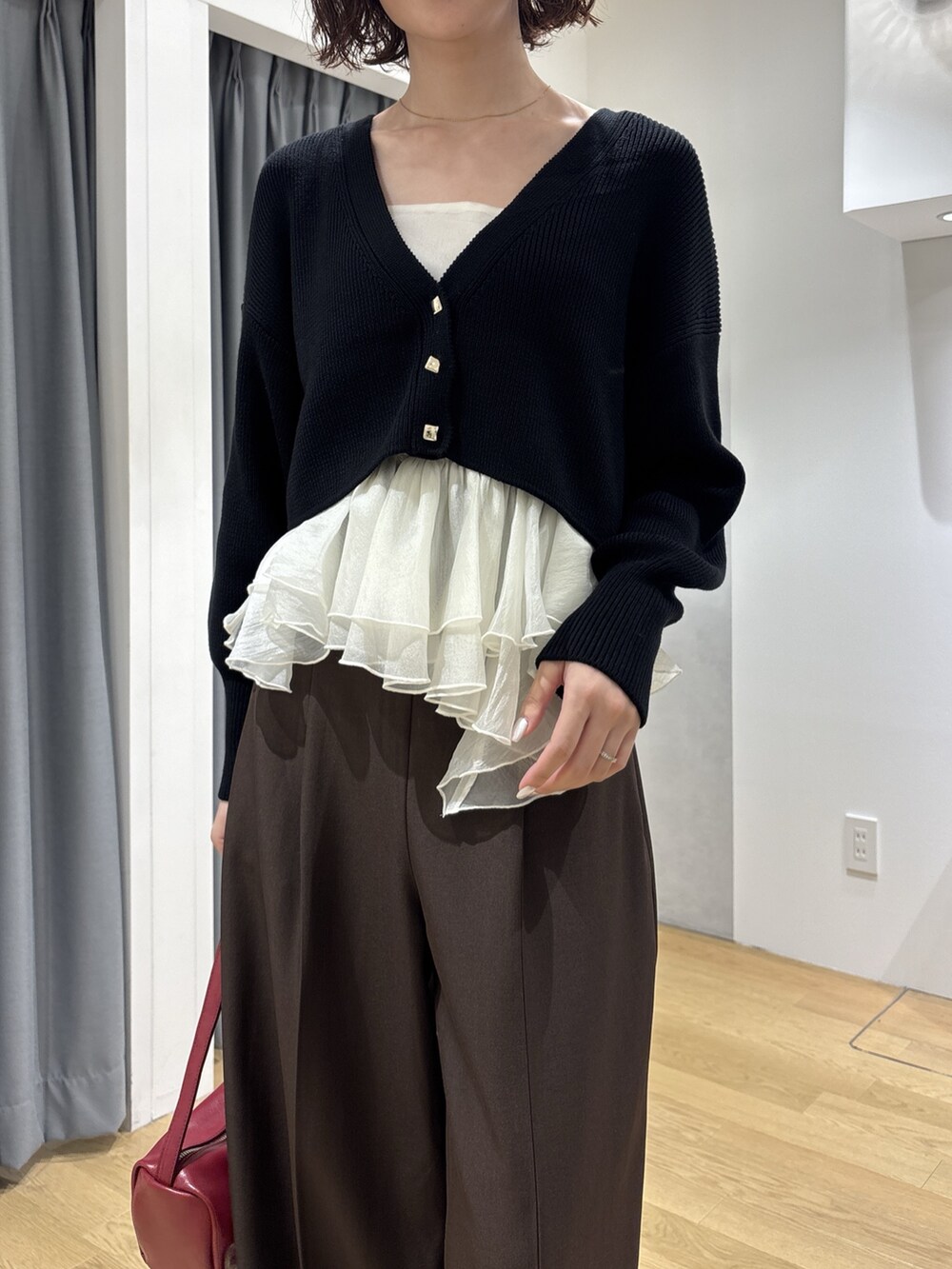 ブラウン系のその他パンツ、ブラック系のカーディガン/ボレロ、レッド系のハンドバッグを着用したレディースの秋コーディネートの5枚目の写真