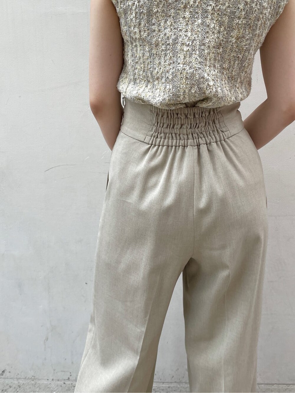 ベージュ系のその他パンツ、グレー系のニット/セーターを着用したレディースの夏コーディネートの7枚目の写真