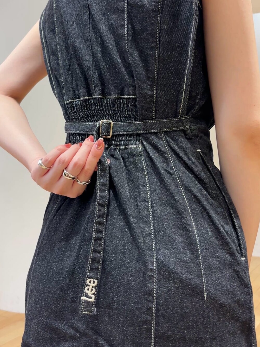 ブラック系のワンピース、ブラック系のサンダル、イエロー系のハンドバッグを着用したレディースの夏コーディネートの7枚目の写真