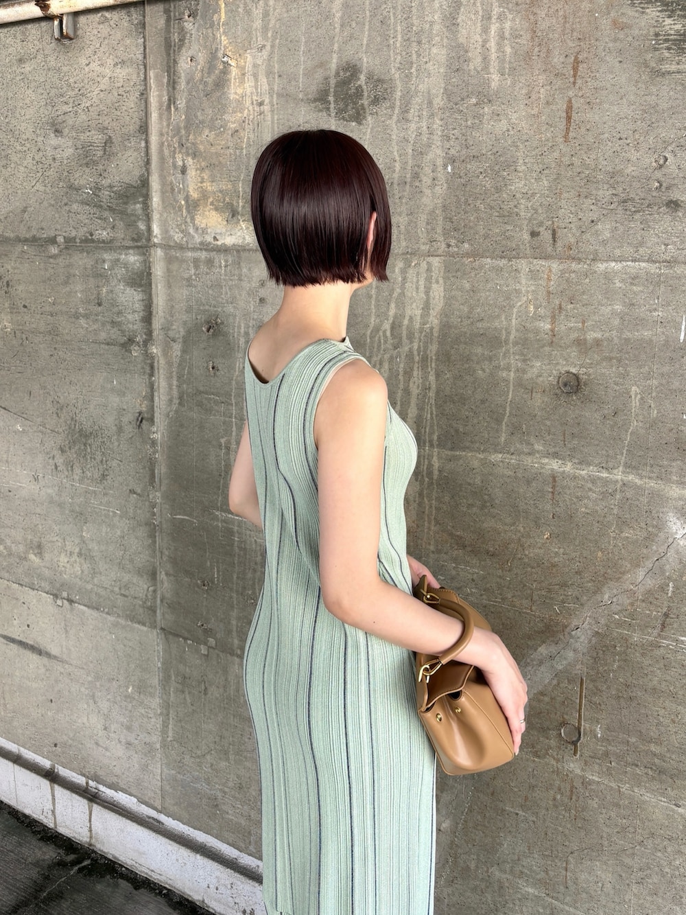 グリーン系のワンピース、ブラック系のサンダル、イエロー系のハンドバッグを着用したレディースの春コーディネートの6枚目の写真