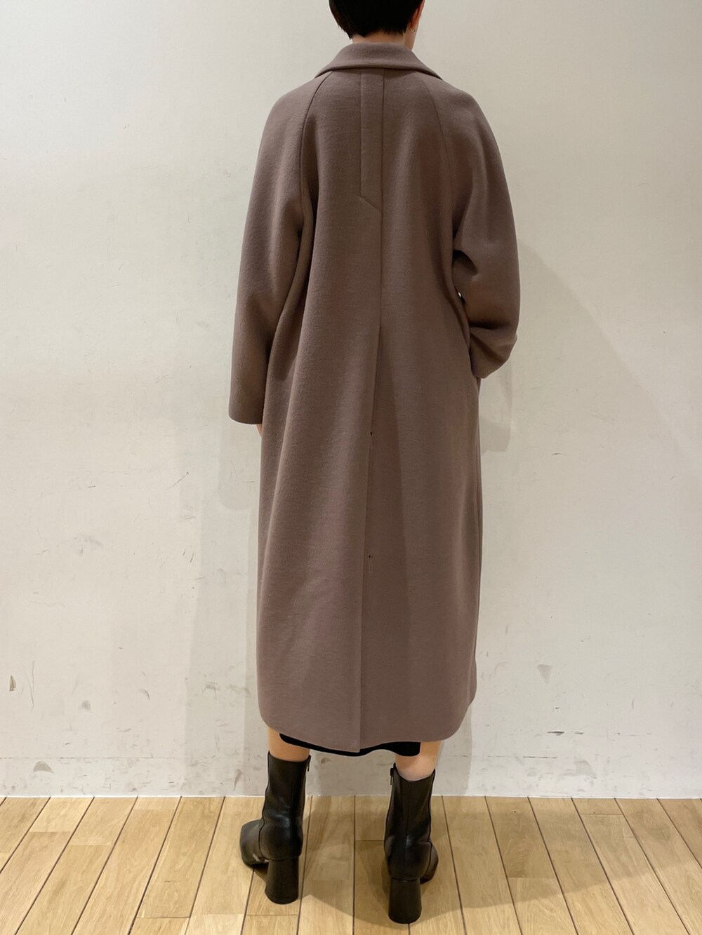 ホワイト系のニット/セーター、ブラック系のスカート、ブラック系のブーツを着用したレディースの冬コーディネートの8枚目の写真