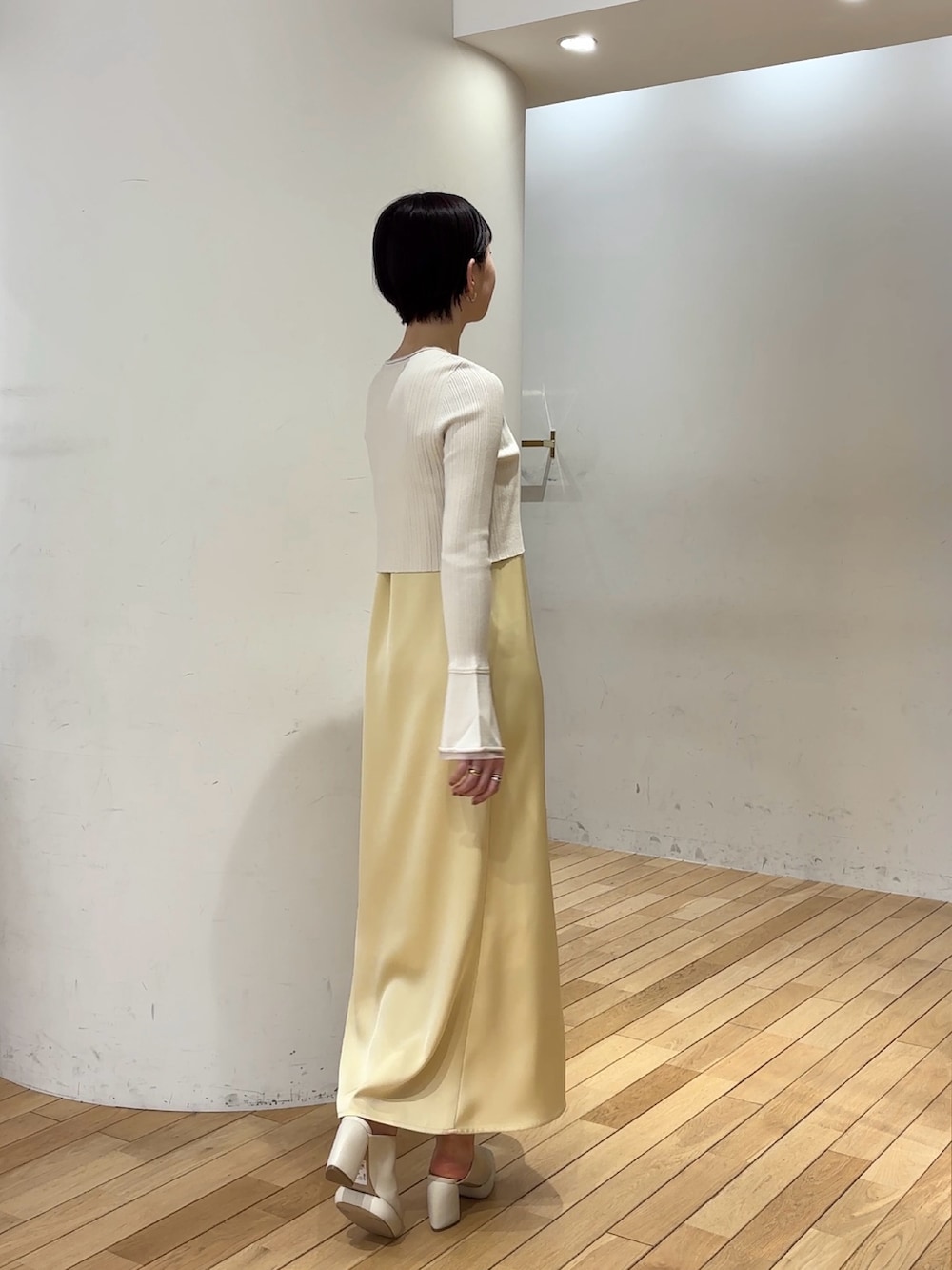 ホワイト系のワンピース、ホワイト系のサンダル、ブルー系のアンサンブルを着用したレディースの春コーディネートの4枚目の写真