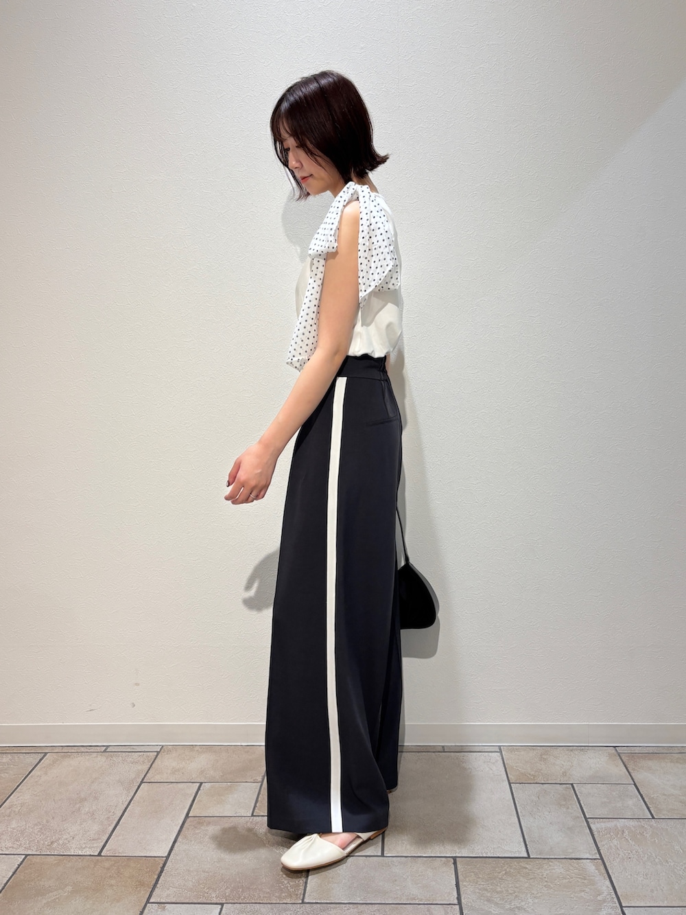 グレー系のその他パンツ、ホワイト系のサンダル、ブラック系のハンドバッグを着用したレディースの夏コーディネートの4枚目の写真