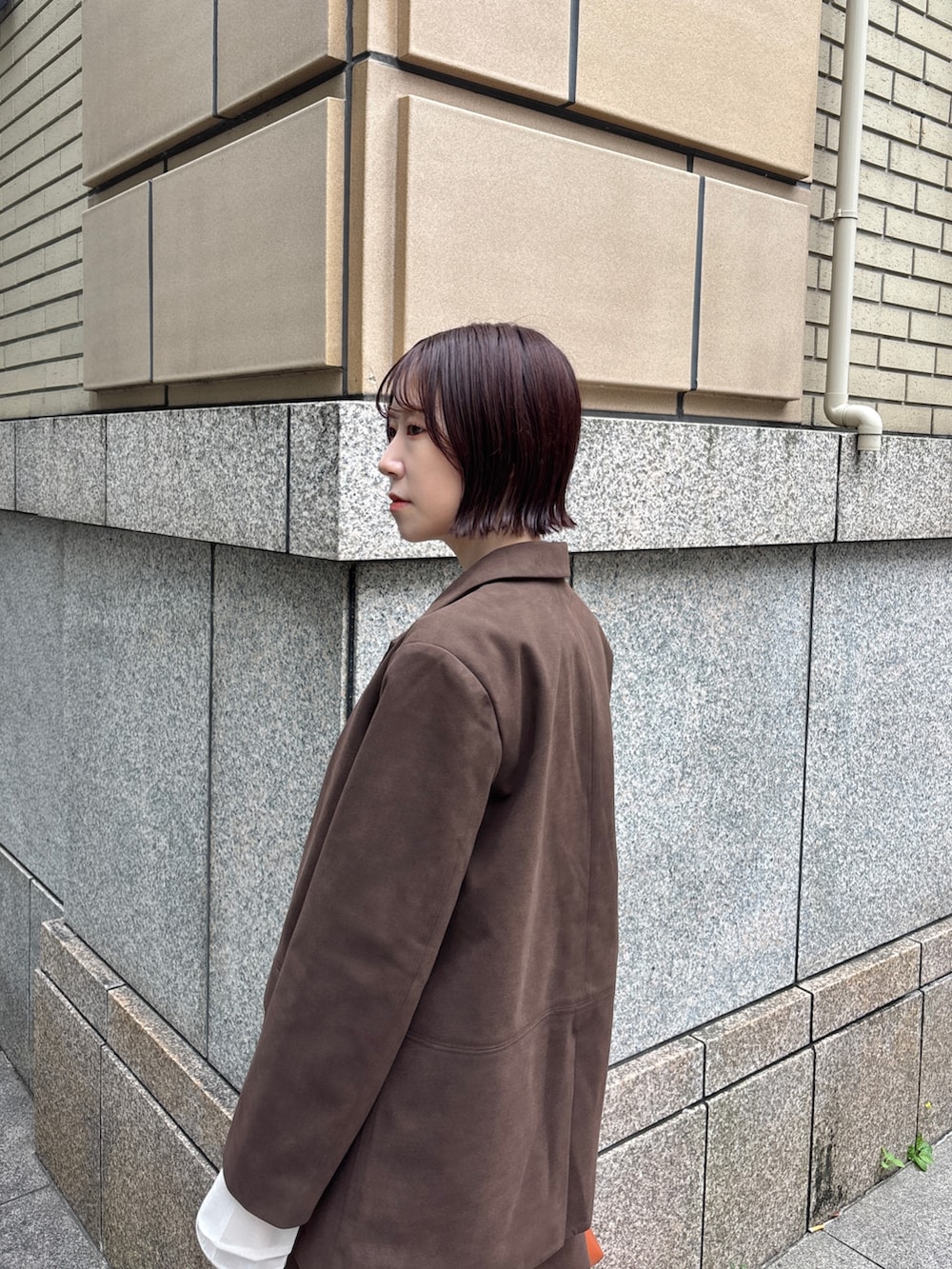 ブラウン系のブーツ、ブラウン系のハンドバッグ、ブラウン系のスカートを着用したレディースの秋コーディネートの3枚目の写真