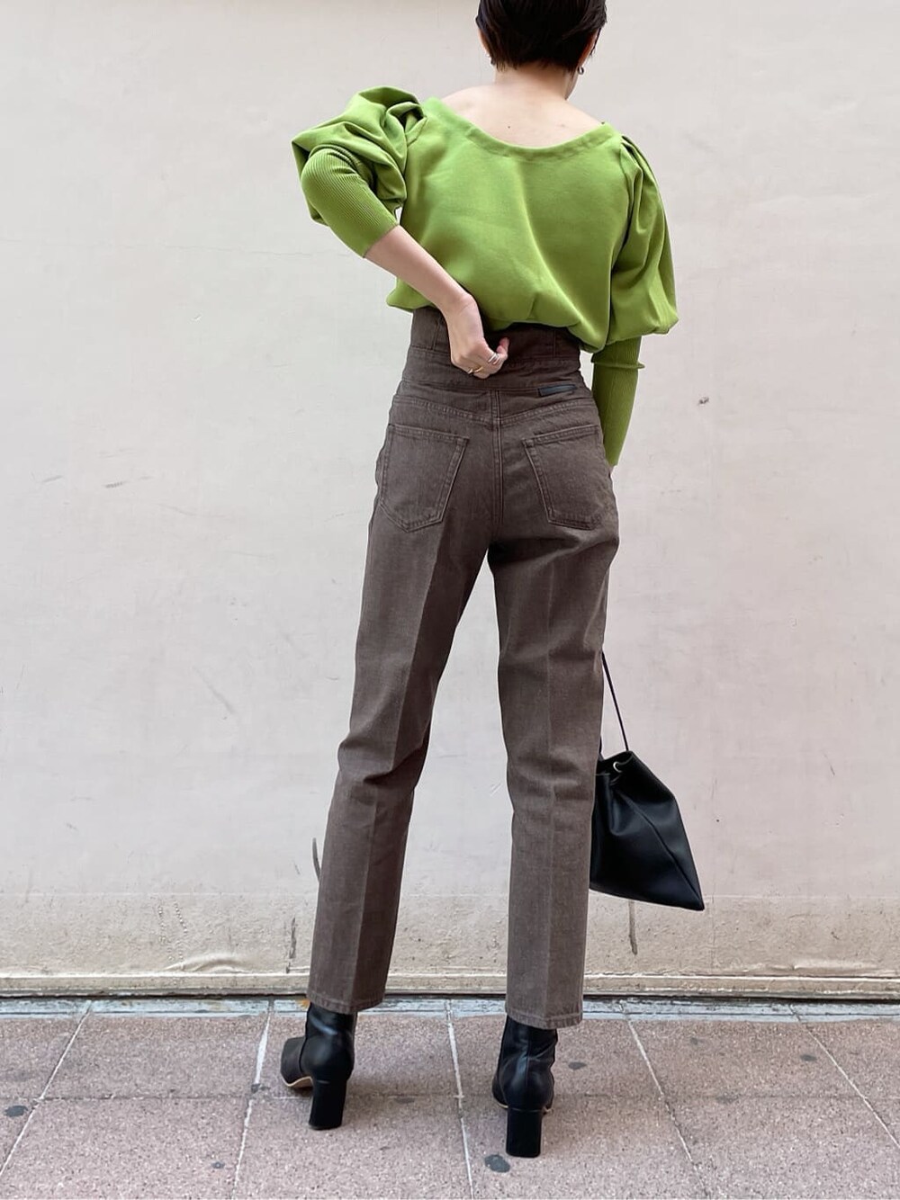 ブラック系のその他シューズ、ブラック系のハンドバッグ、グリーン系のニット/セーターを着用したレディースの冬コーディネートの4枚目の写真