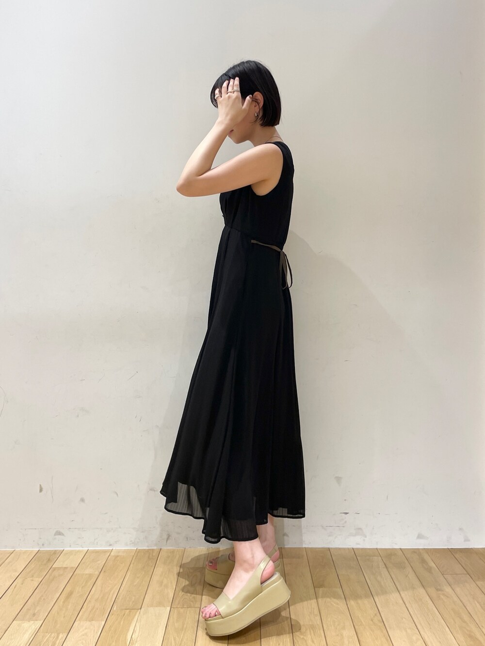 ホワイト系のショルダーバッグ、ベージュ系のサンダル、ブラック系のワンピースを着用したレディースの夏コーディネートの3枚目の写真