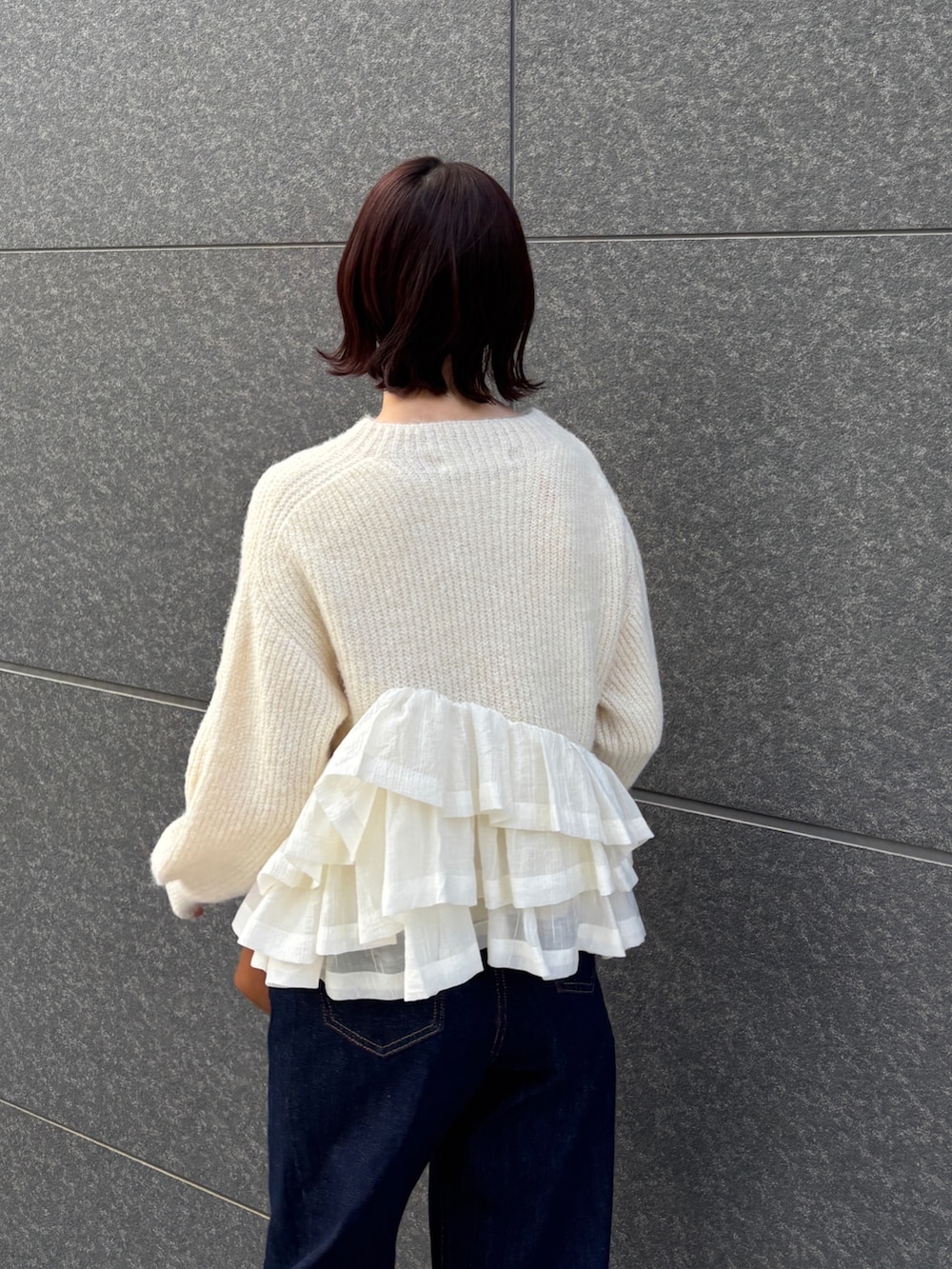 ブルー系のデニムパンツ、イエロー系のハンドバッグ、ホワイト系のニット/セーターを着用したレディースの冬コーディネートの5枚目の写真