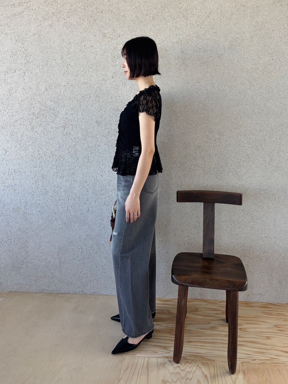 グレー系のデニムパンツ、ブラック系のパンプス、ブラック系のシャツ/ブラウスを着用したレディースの春コーディネートの3枚目の写真