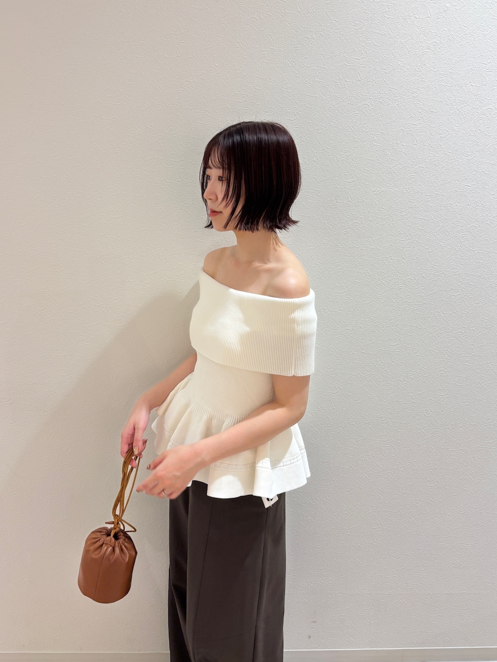 ブラウン系のその他パンツ、ホワイト系のニット/セーター、イエロー系のハンドバッグを着用したレディースの夏コーディネートの5枚目の写真