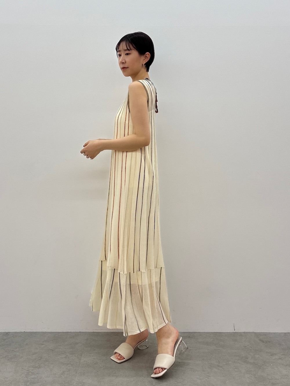 ホワイト系のワンピース、ホワイト系のサンダル、シルバー系のネックレスを着用したレディースの春コーディネートの3枚目の写真