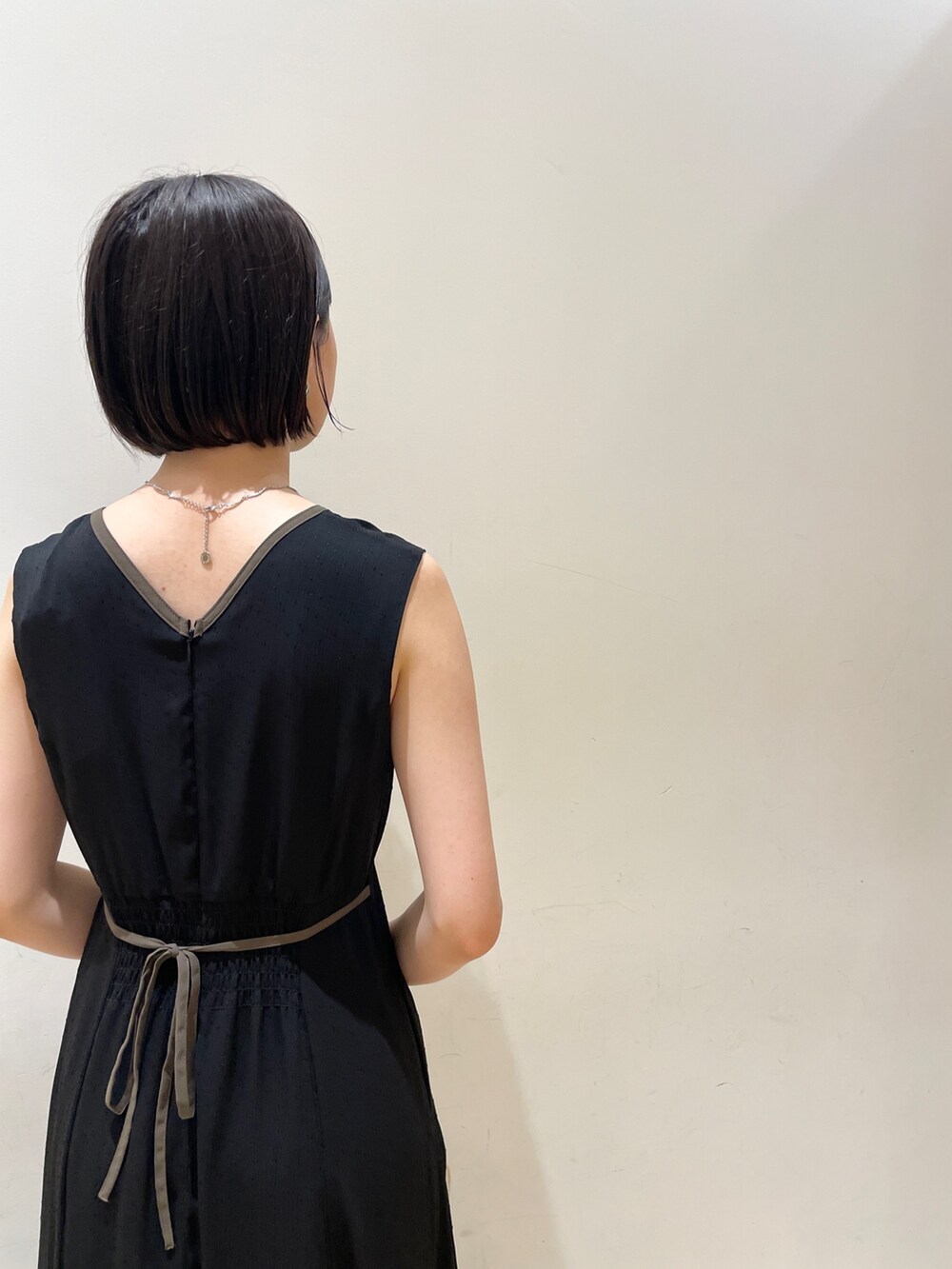 ホワイト系のショルダーバッグ、ベージュ系のサンダル、ブラック系のワンピースを着用したレディースの夏コーディネートの7枚目の写真