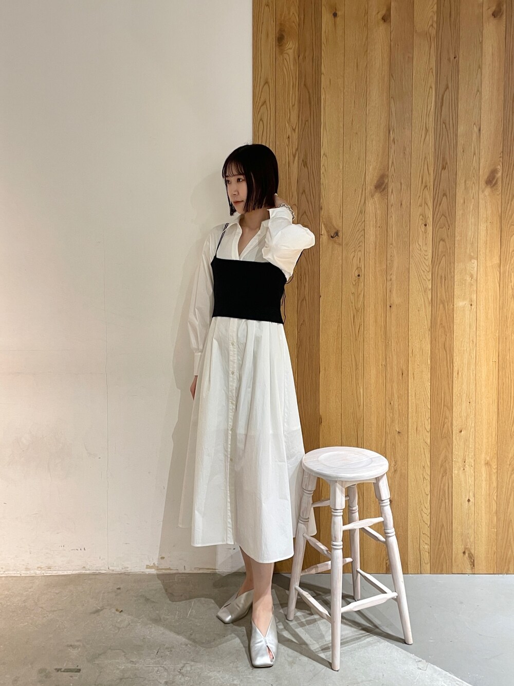 シルバー系のパンプス、ホワイト系のシャツワンピース、ブラック系のデニムジャケットを着用したレディースの冬コーディネートの2枚目の写真