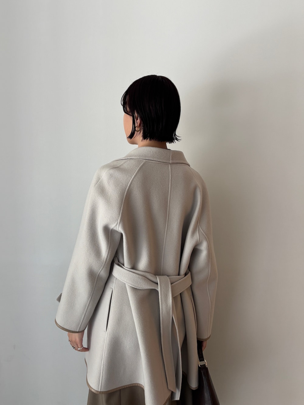 ホワイト系のワンピース、ブラウン系のブーツ、ブラウン系のハンドバッグを着用したレディースの秋コーディネートの3枚目の写真