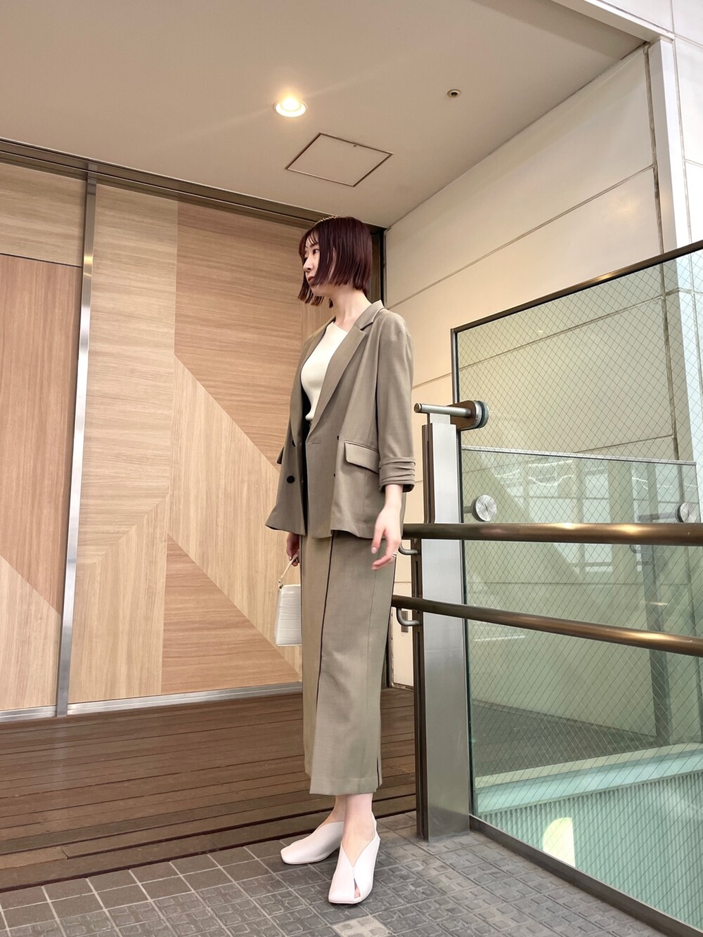 ホワイト系のパンプス、ブラウン系のテーラードジャケット、ホワイト系のニット/セーターを着用したレディースの春コーディネートの3枚目の写真