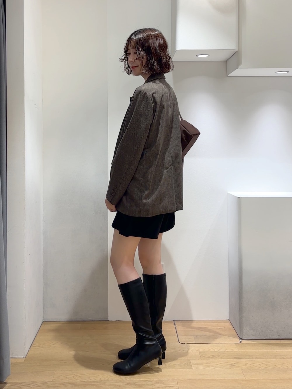 ブルー系のニット/セーター、ブラック系のその他パンツ、ブラック系のブーツを着用したレディースの秋コーディネートの2枚目の写真
