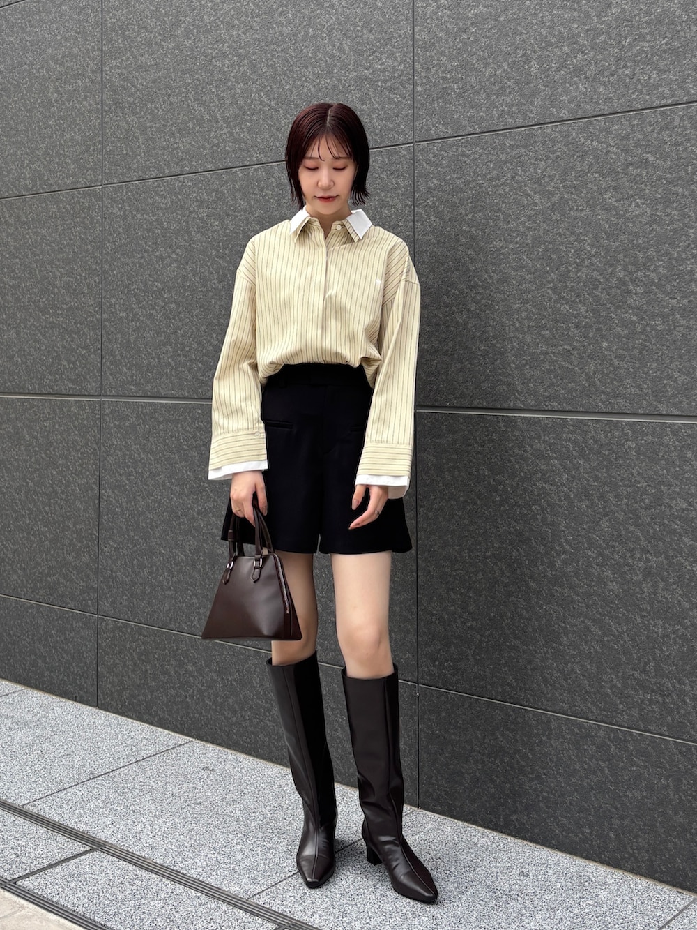 イエロー系のシャツ/ブラウス、ブラック系のその他パンツ、ブラウン系のブーツを着用したレディースの秋コーディネートの2枚目の写真