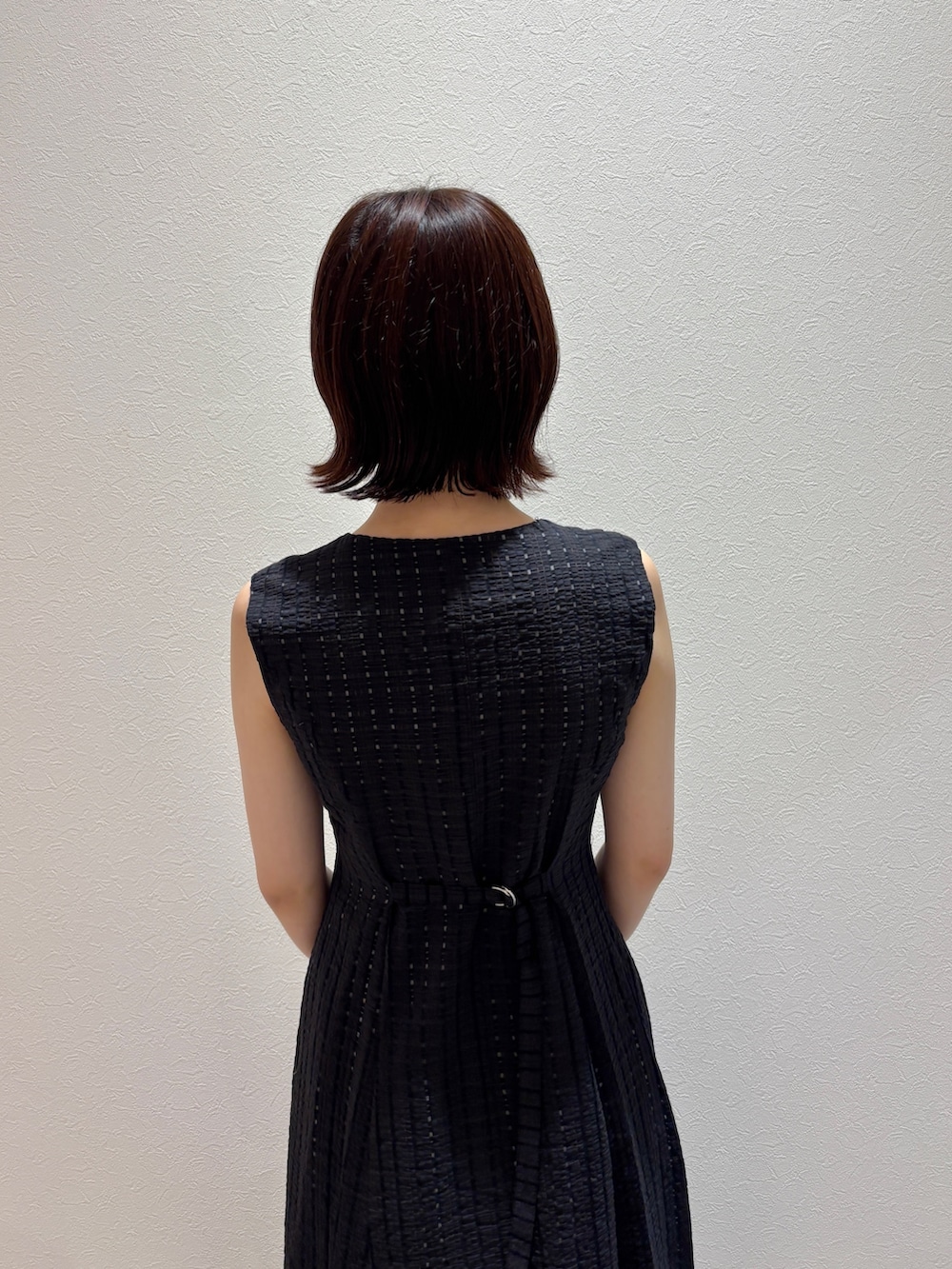 ブラック系のワンピース、ブラック系のハンドバッグ、グリーン系のパンプスを着用したレディースの夏コーディネートの6枚目の写真