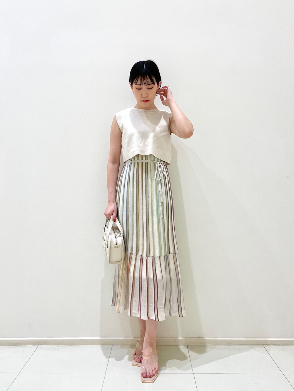 ブルー系のテーラードジャケット、ホワイト系のワンピース、ホワイト系のショルダーバッグを着用したレディースの春コーディネートの6枚目の写真