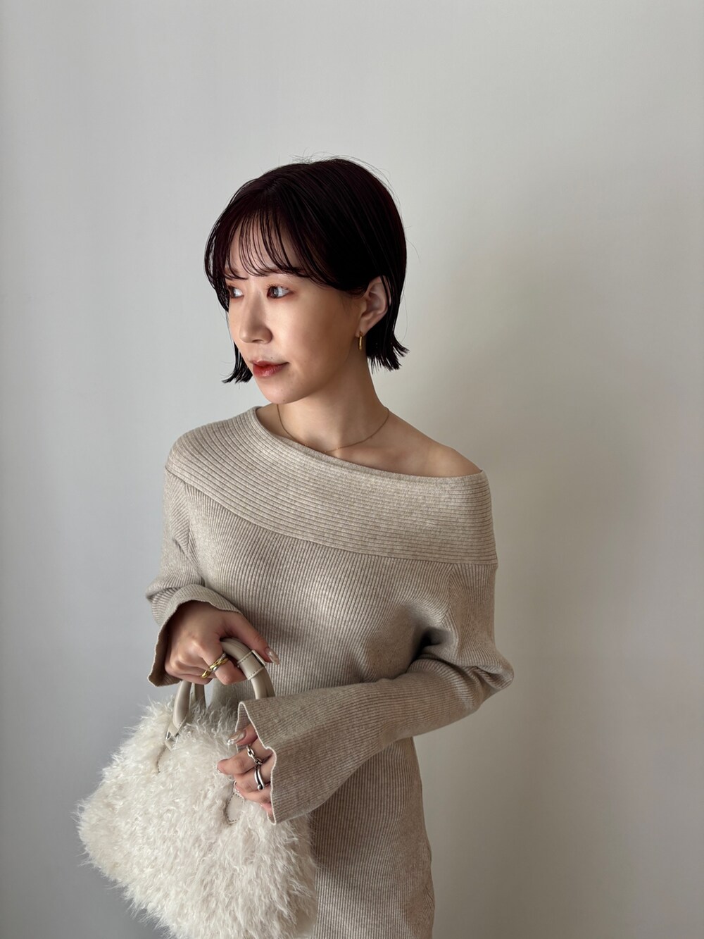 ベージュ系のワンピース、ホワイト系のボストンバッグ、ブラウン系のブーツを着用したレディースの秋コーディネートの5枚目の写真