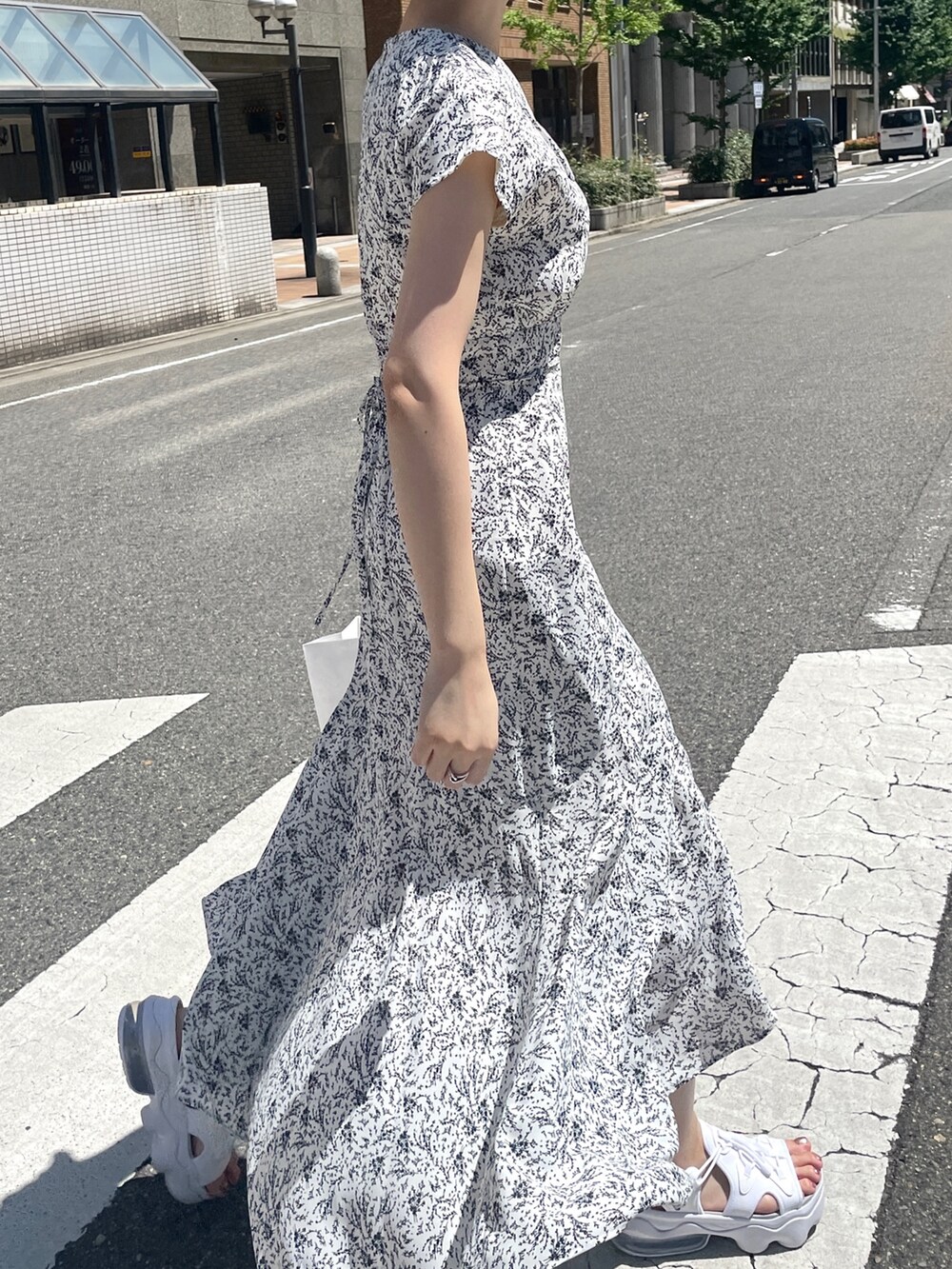 ホワイト系のワンピース、ホワイト系のハンドバッグを着用したレディースの夏コーディネートの6枚目の写真