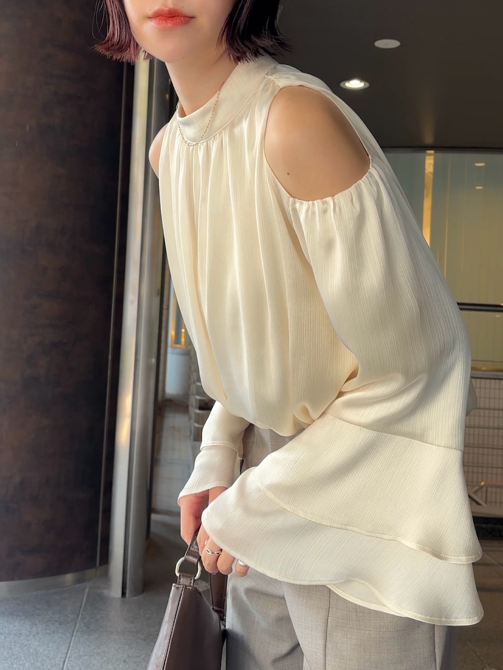 シルバー系のパンプス、ブラウン系のハンドバッグ、グレー系のその他パンツを着用したレディースの冬コーディネートの6枚目の写真