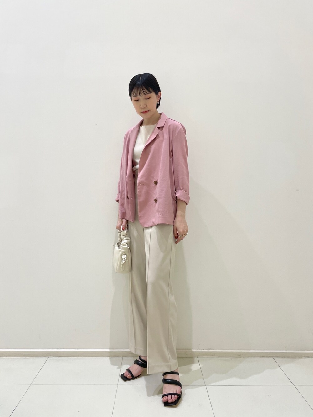 ピンク系のテーラードジャケット、ホワイト系のその他パンツ、ホワイト系のニット/セーターを着用したレディースの春コーディネートの2枚目の写真