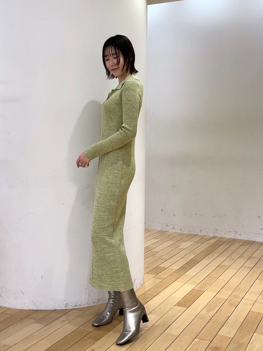 グリーン系のワンピース、シルバー系のブーツを着用したレディースの冬コーディネートの2枚目の写真