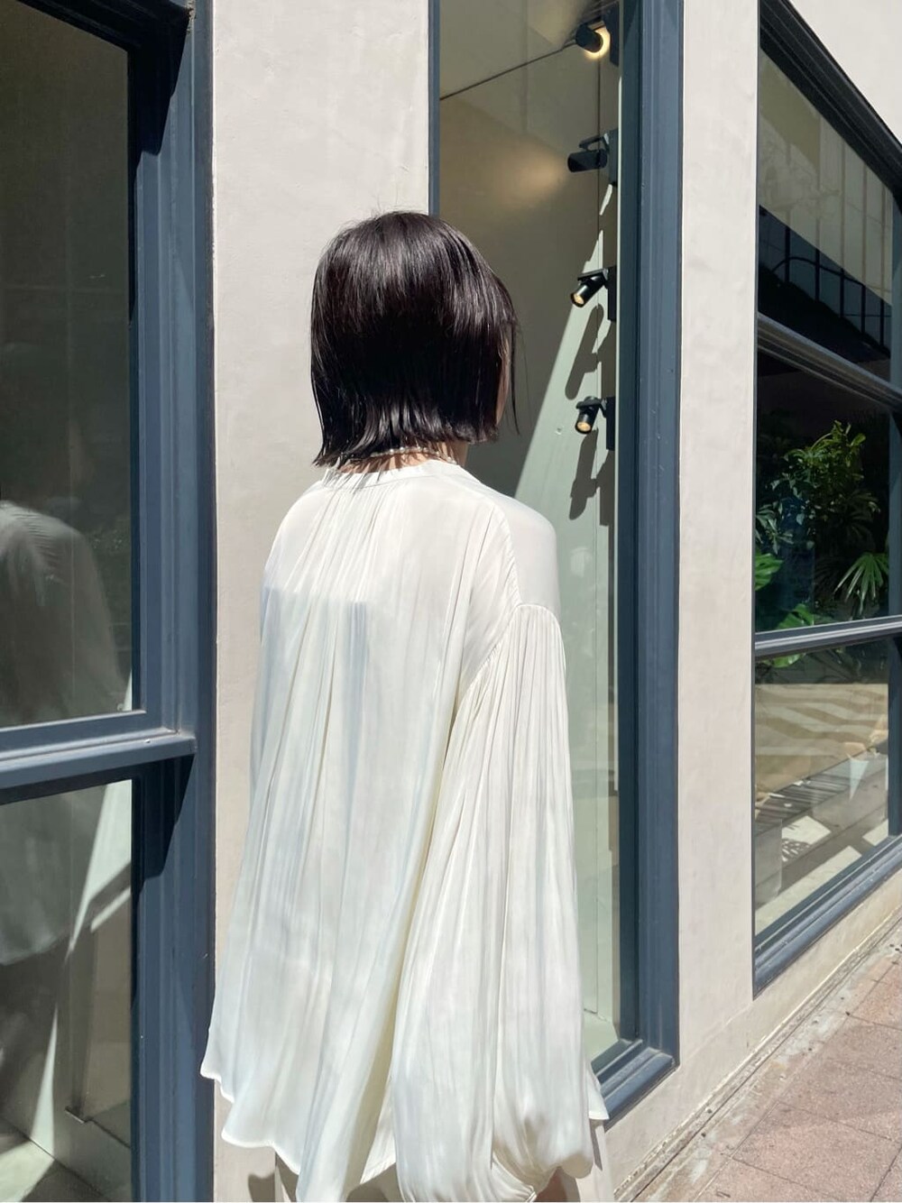 ホワイト系のシャツ/ブラウス、ホワイト系のその他シューズ、ベージュ系のその他アウターを着用したレディースの秋コーディネートの6枚目の写真