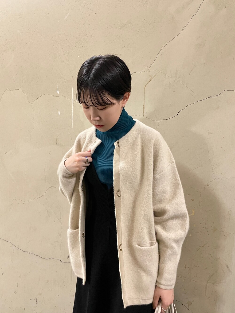 ブラック系のスカート、グリーン系のニット/セーター、ブラック系のブーツを着用したレディースの秋コーディネートの5枚目の写真