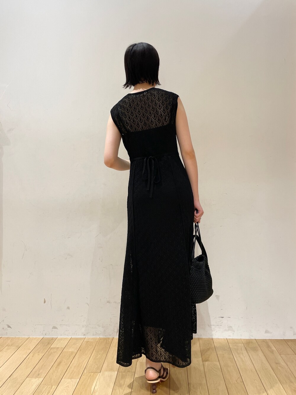 ブラック系のワンピース、ブラック系のハンドバッグ、ブラウン系のサンダルを着用したレディースの夏コーディネートの6枚目の写真