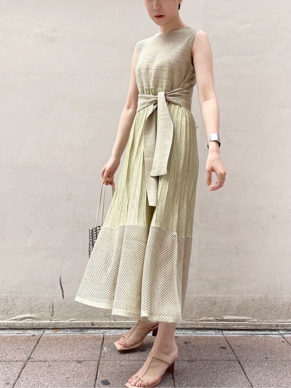 ベージュ系のサンダル、グリーン系のワンピース、ホワイト系のハンドバッグを着用したレディースの夏コーディネートの2枚目の写真